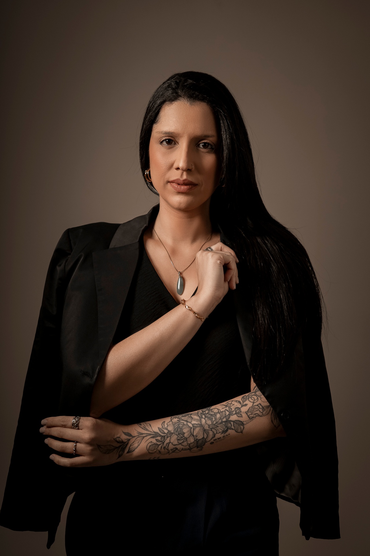 Retrato de Giselli Duarte de blazer preto.